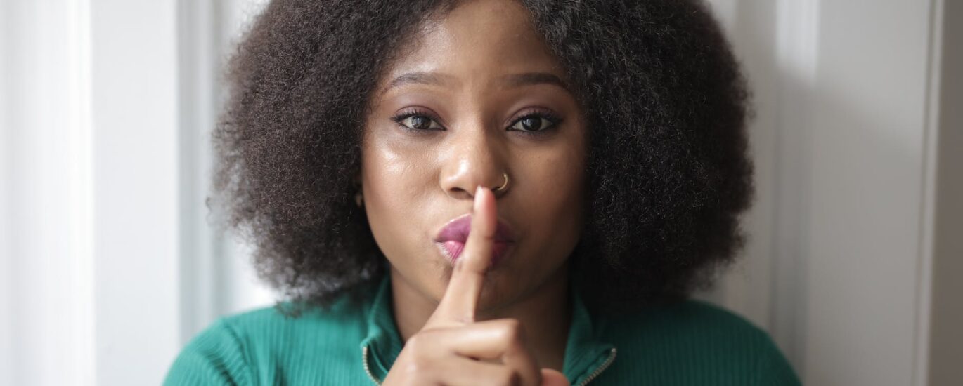 woman doing shh hand gesture