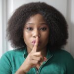 woman doing shh hand gesture